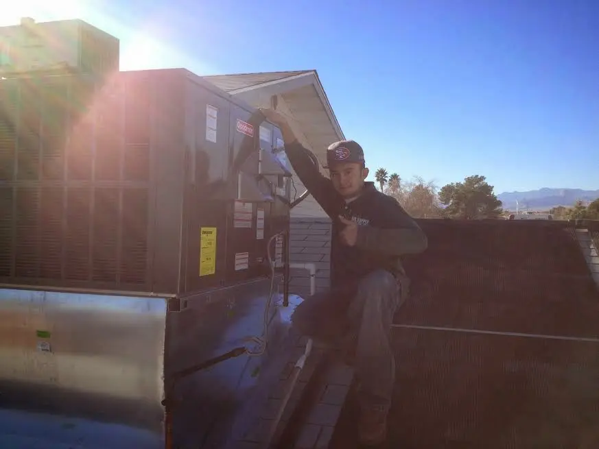 HVAC technician performing Boiler Repair on a rooftop unit in Douglass